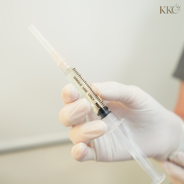 มือที่สวมถุงมือถือเข็มฉีดยาที่มีข้อความ “Single Use Only” ที่ KKC Clinic