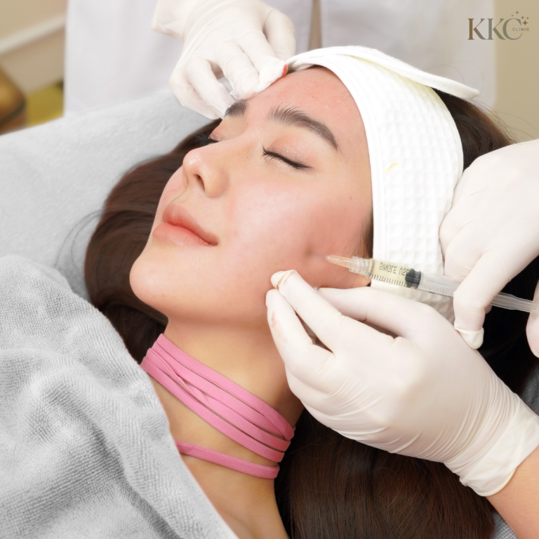 ผู้หญิงกำลังรับการฉีดยาที่แก้มขณะนอนอยู่ที่ KKC Clinic