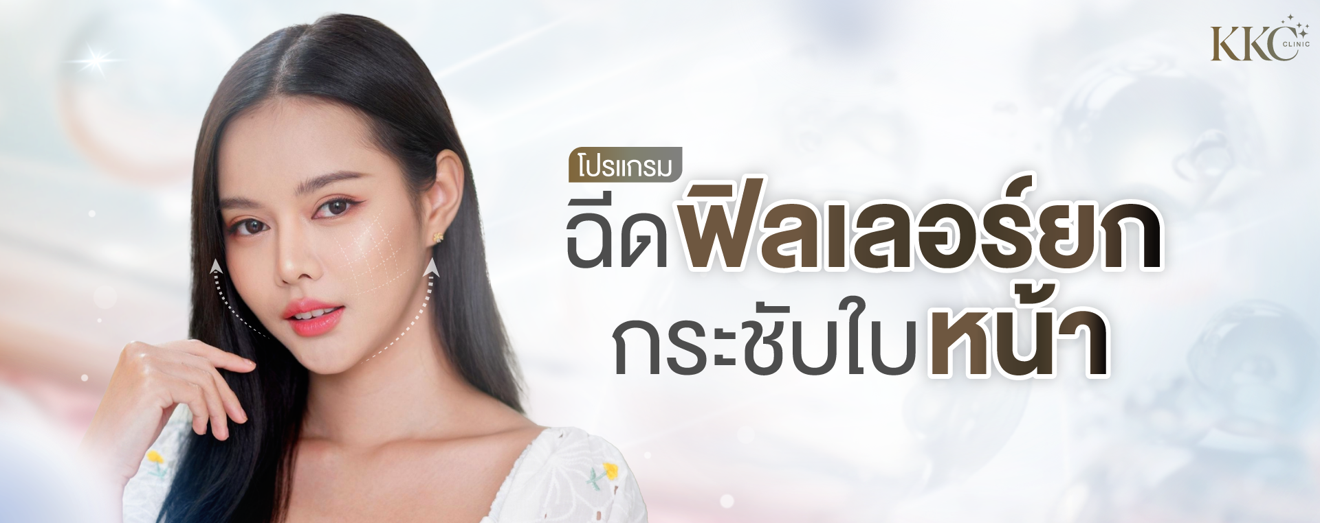 หญิงสาวผิวเรียบเนียนผมสีดำกำลังสัมผัสคางเบาๆ และมองไปข้างหน้า มีเส้นประบนแก้มแสดงจุดยกกระชับ