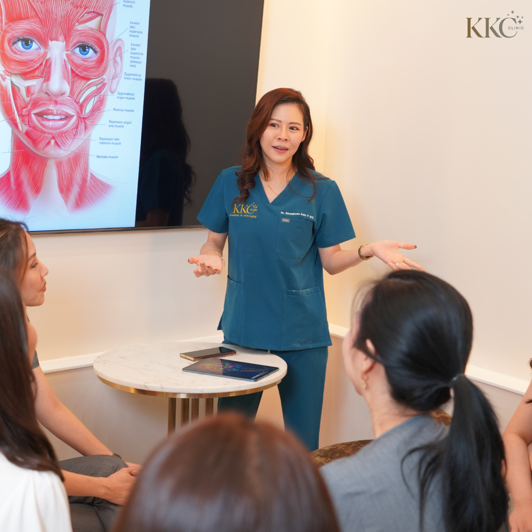 พญ.ของขวัญ ฟูจิตนิรันดร์ กำลังบรรยายเรื่องกายวิภาคของใบหน้าให้กับกลุ่มผู้ฟัง พร้อมภาพแสดงกล้ามเนื้อบนหน้าจอที่คลินิก KKC Clinic