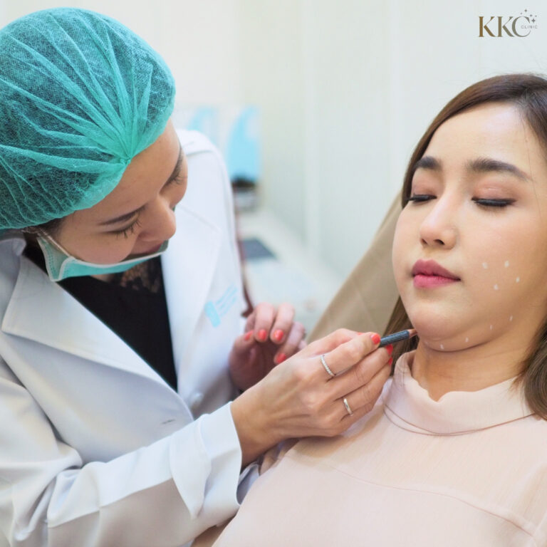Doctor marking injection points under the chin of a female patient in preparation for meso fat dissolving treatment.
