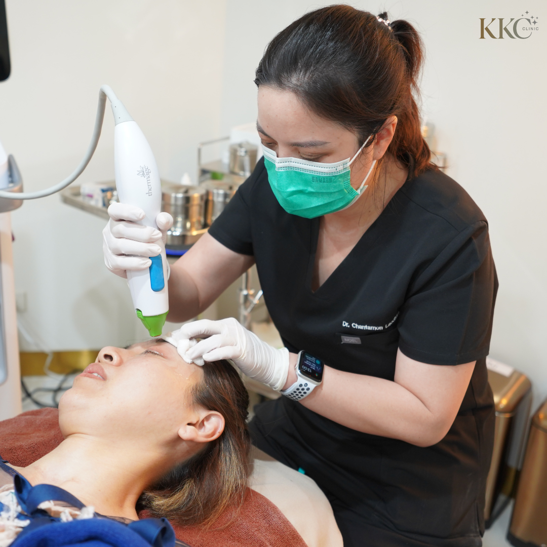 พญ.ฉันทมน เลาจริยกุล กำลังทำทรีตเมนต์ Thermage บริเวณหน้าผากของคนไข้ โดยสวมถุงมือและหน้ากากอนามัย