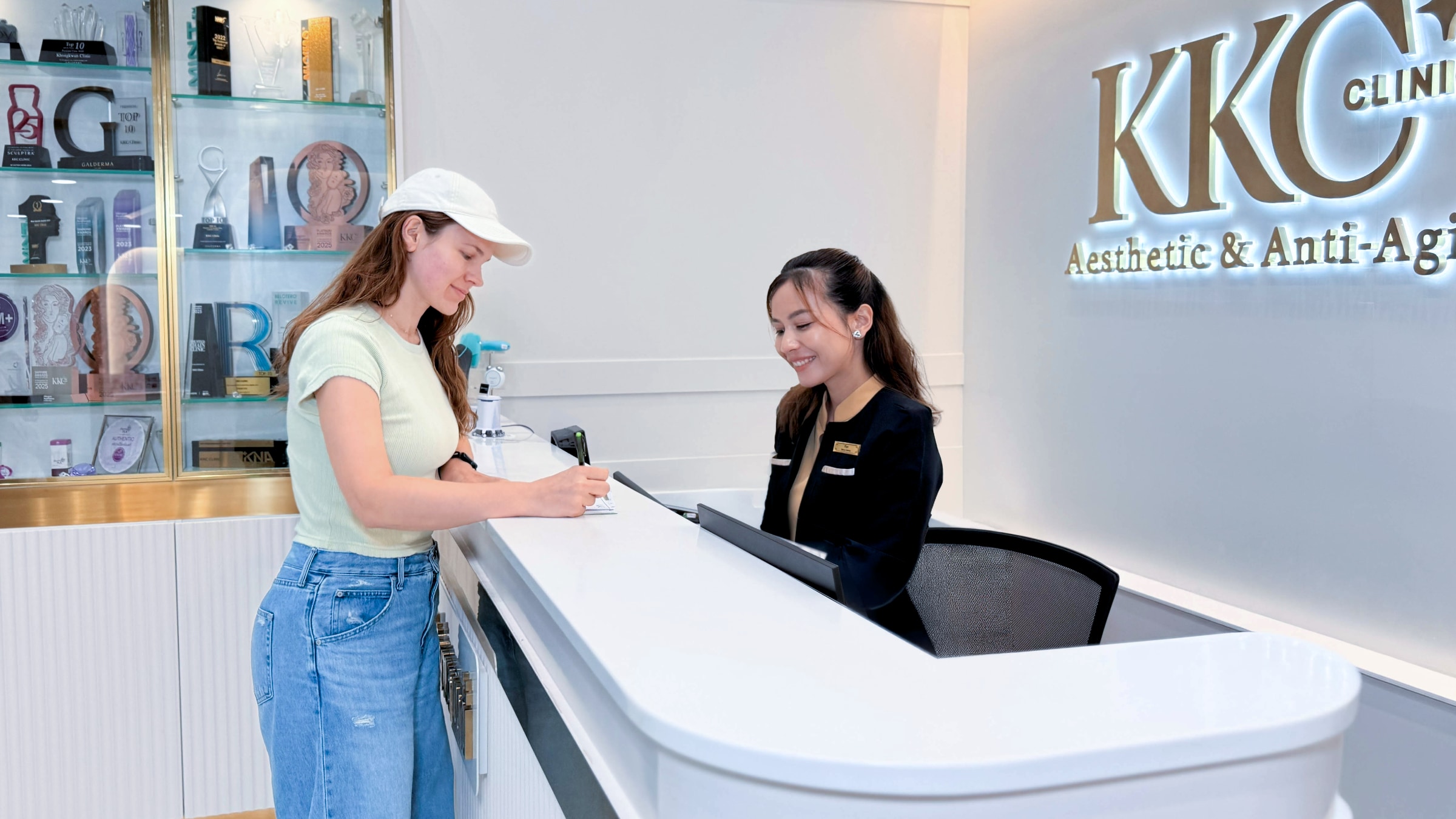 A visitor checking in at the KKC Clinic reception desk with a member of our team.
