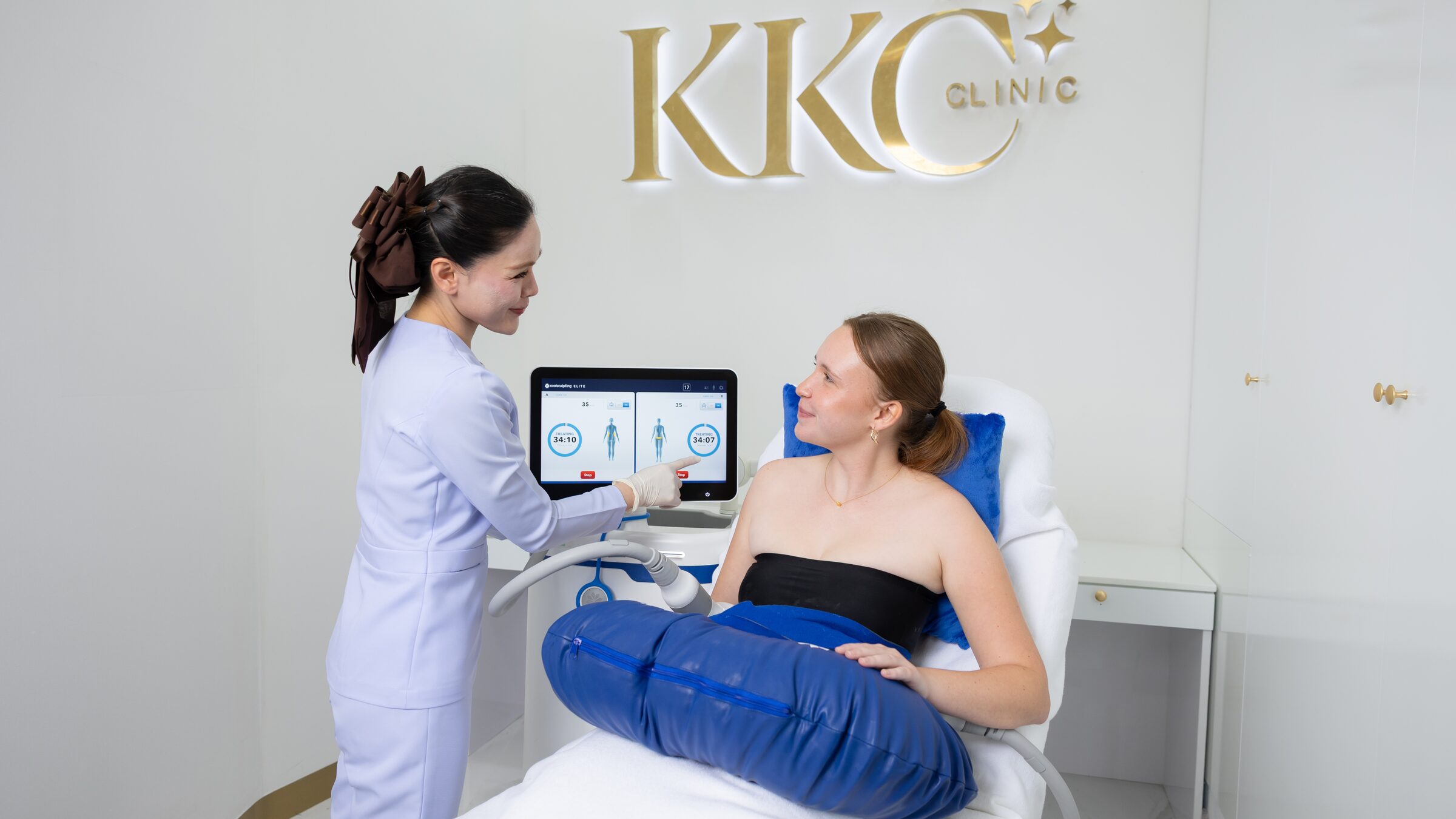 A nurse checks the CoolSculpting Elite screen while two areas are treated at once