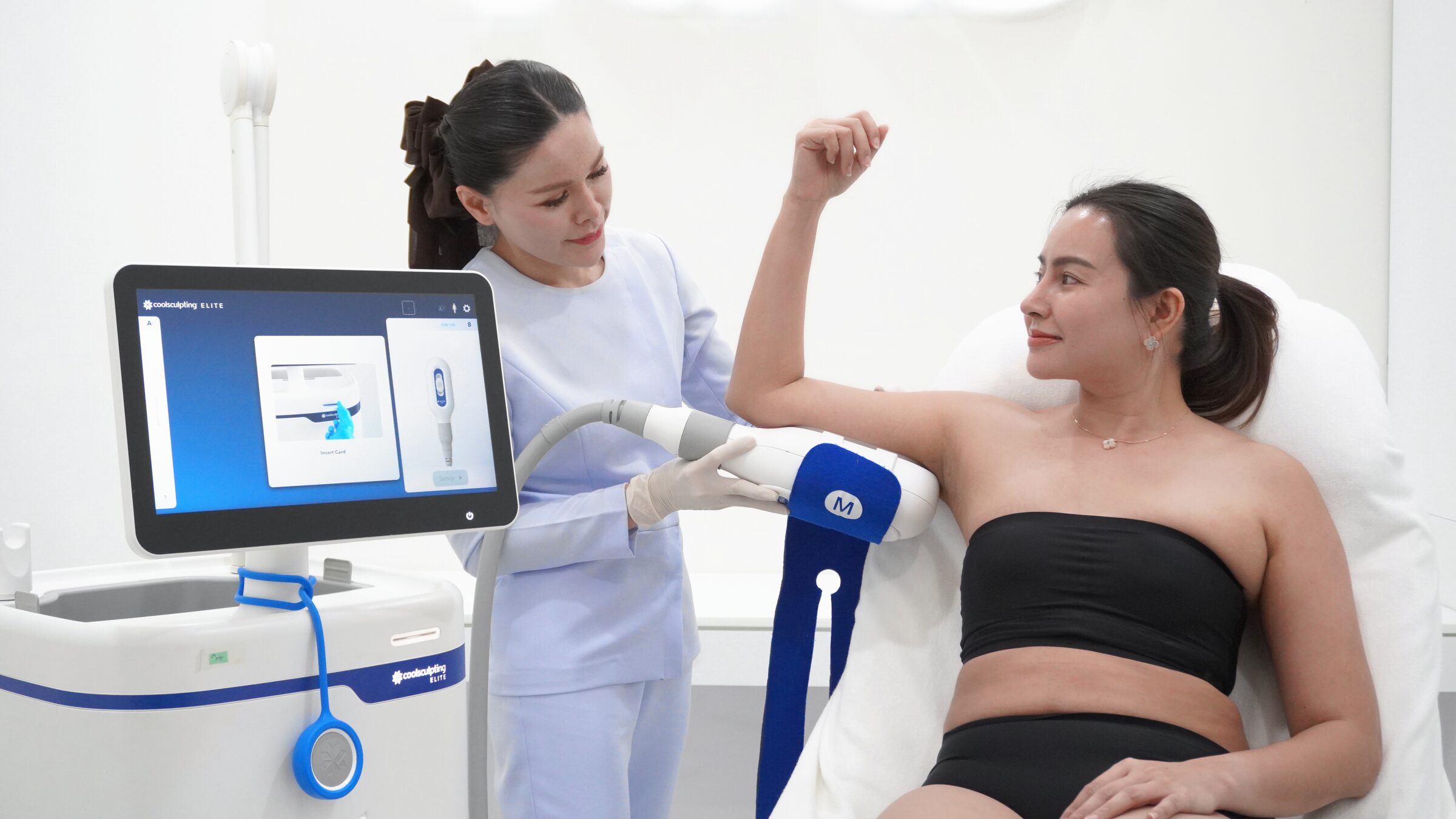 A nurse fits a CoolSculpting Elite applicator to a client's upper arm