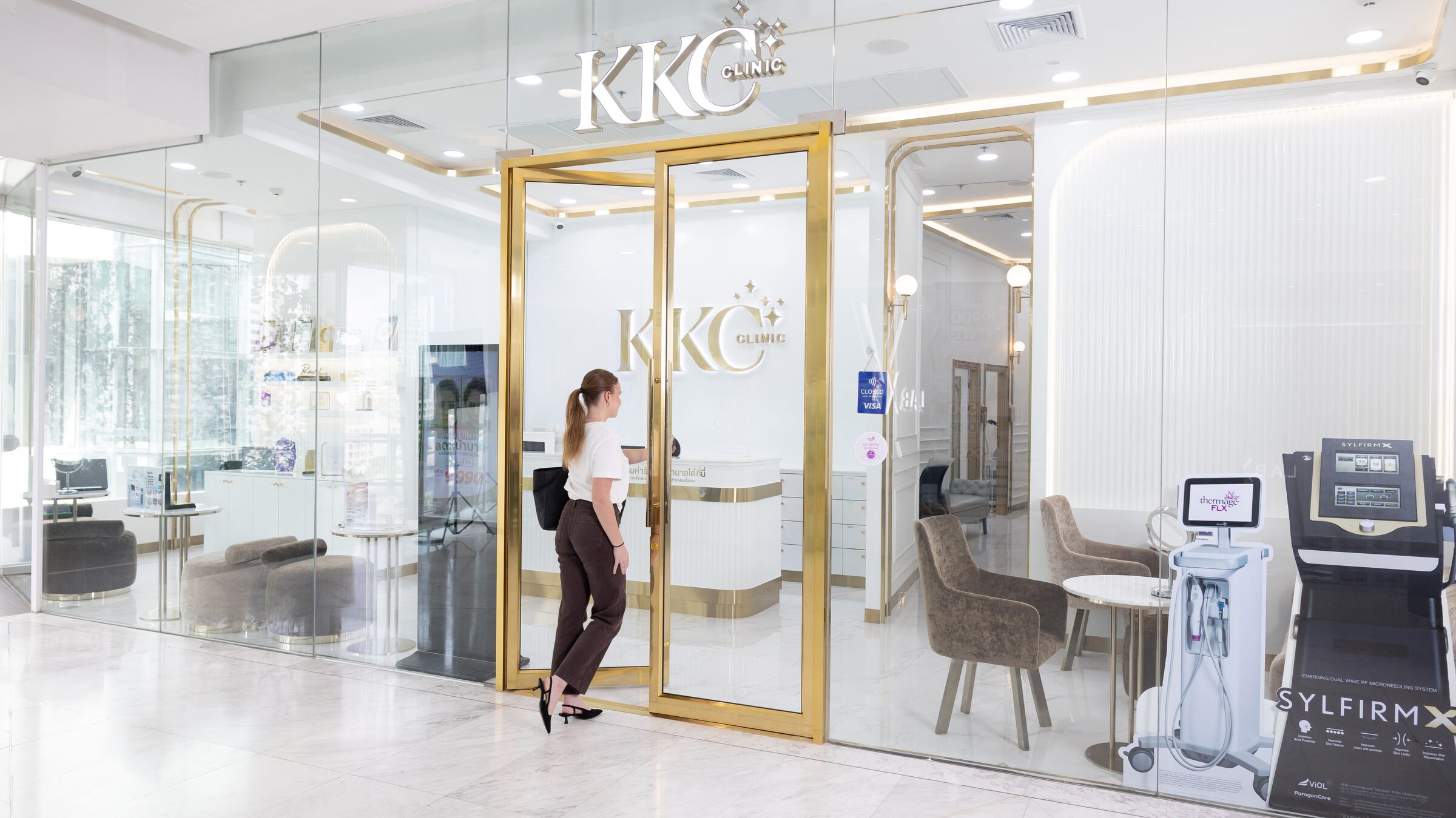 The KKC Clinic storefront at EmQuartier, with a client walking in
